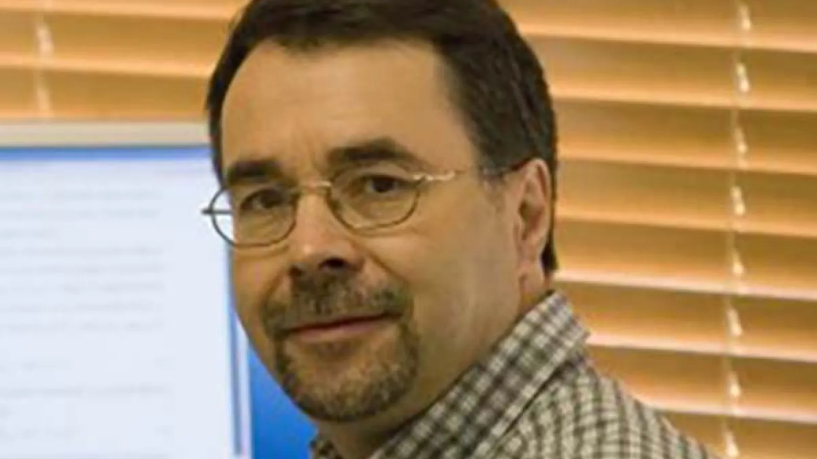 Photograph of Dr. Rafael Bruschweiler in front of computer monitor