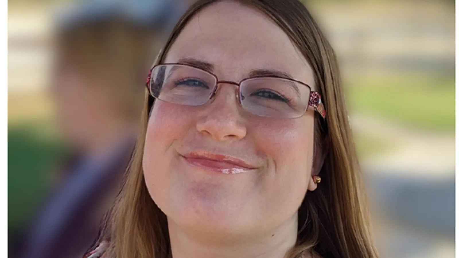 Smiling woman with brunette hair and glasses