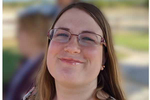 Smiling woman with brunette hair and glasses