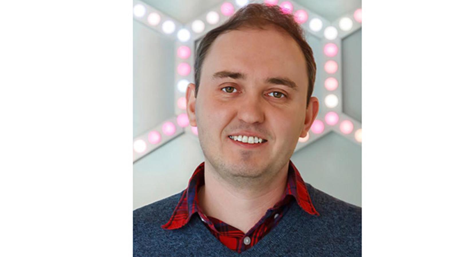 Man standing in front of lit up hexagon-patterned wall