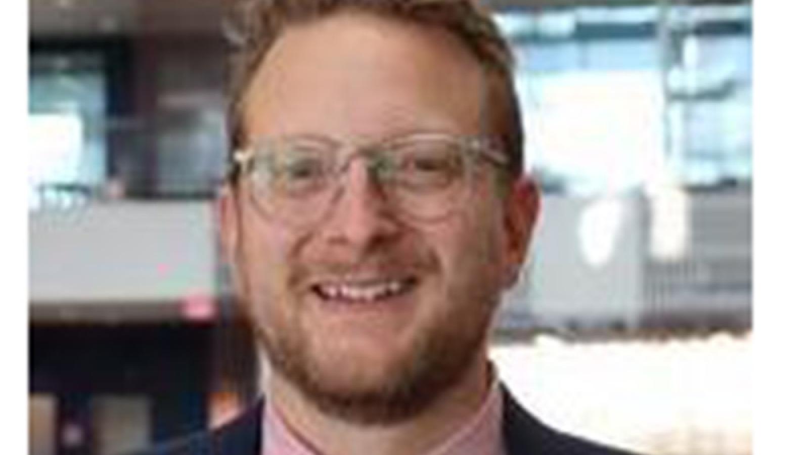 Man with brown hair wearing glasses 